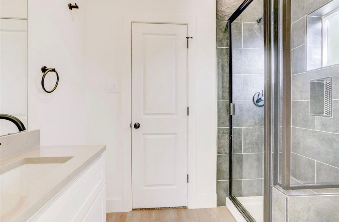 Bathroom with walk-in tile shower and quartz vanity