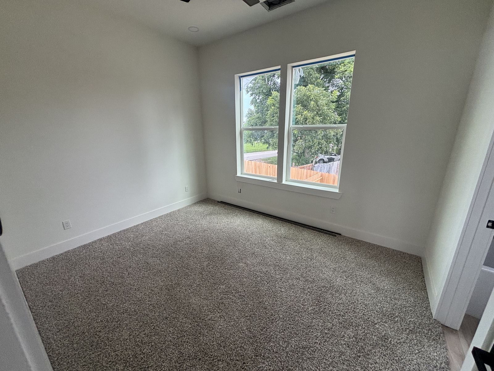 Bedroom with new carpet and large windows
