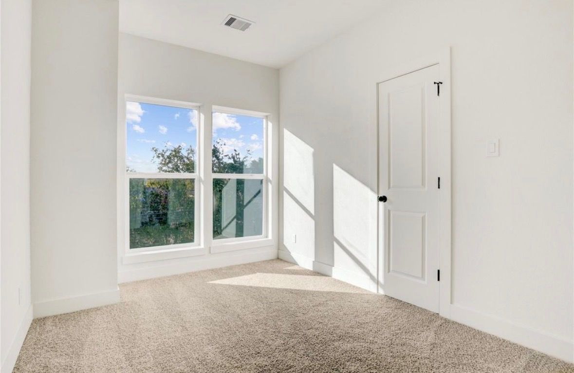 Bedroom corner with large windows and new carpet