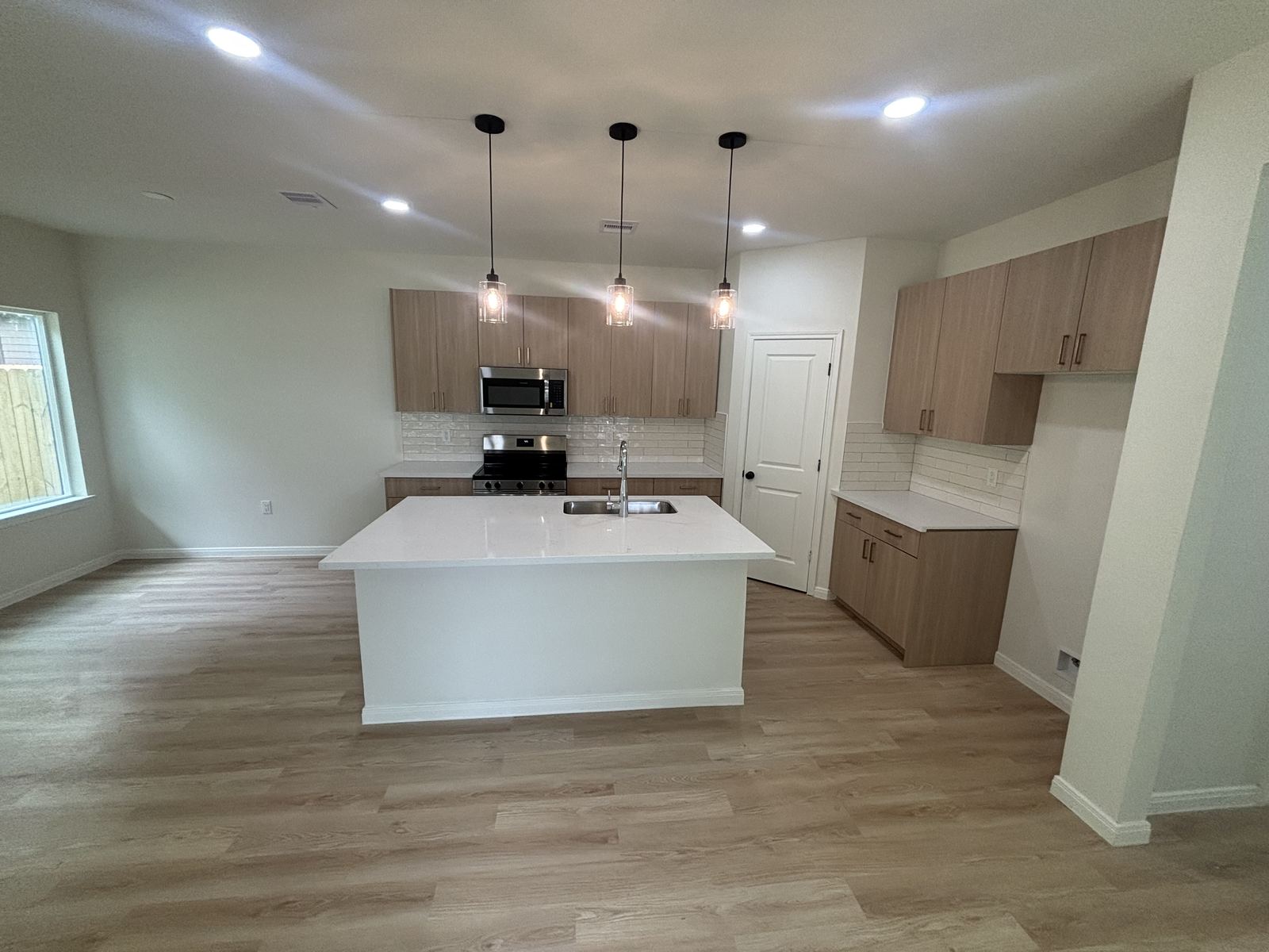 Open concept kitchen and living area with light wood cabinetry
