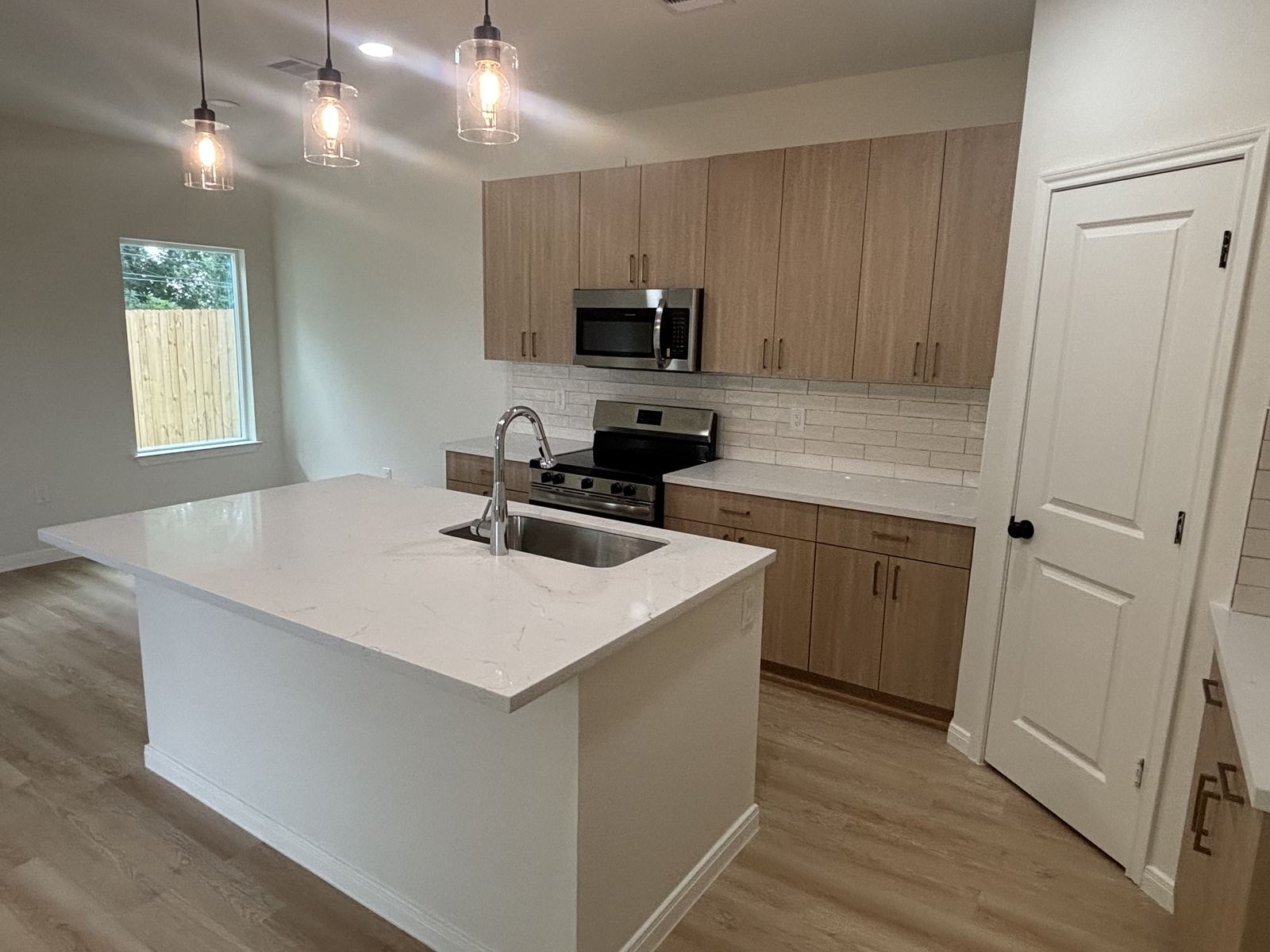 Light wood kitchen with island and pendant lighting