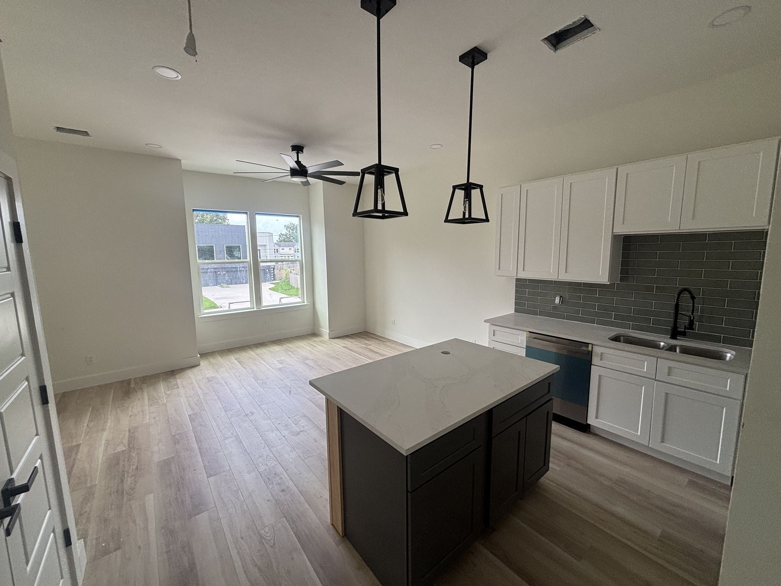 White kitchen cabinetry with charcoal island and gray subway tile