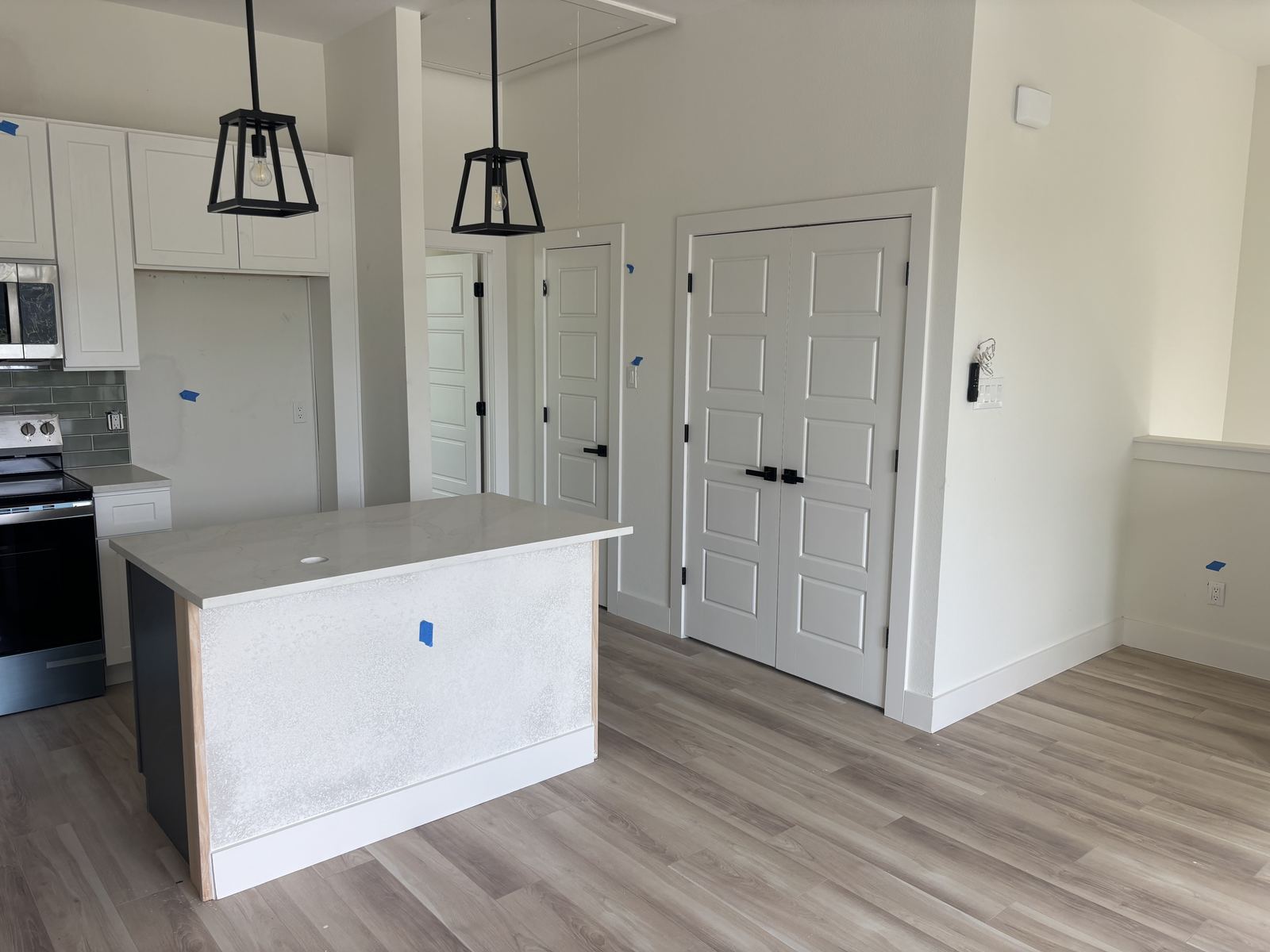 White kitchen cabinetry adjoining hallway with double doors