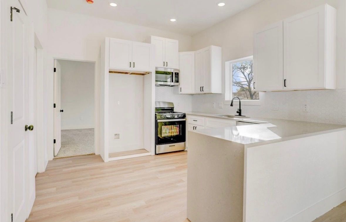 White kitchen cabinetry with open hallway layout