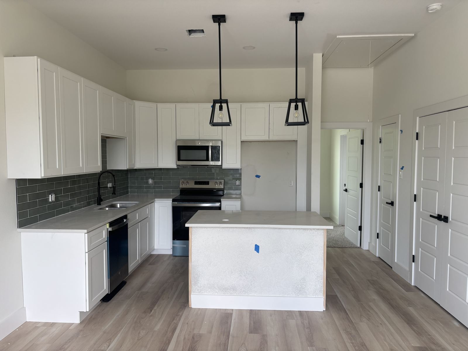 Wide view of white kitchen cabinetry with island