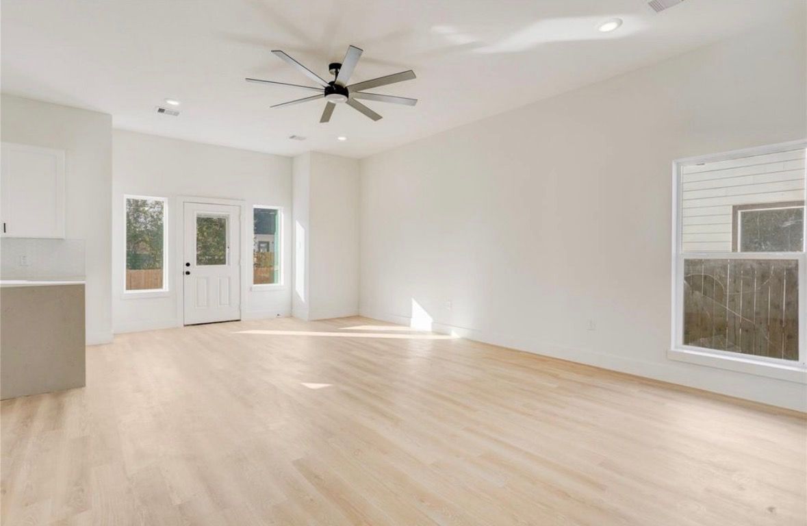 Living room with light wood flooring and ceiling fan